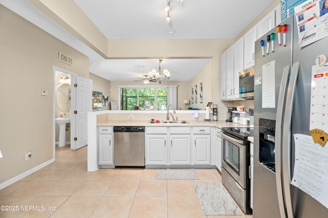 7540 Scarlet Ibis Ln, Jacksonville, FL 32256 - kitchen with a sink, appliances with stainless steel finishes, a peninsula, white cabinets, and light tile patterned floors