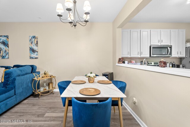 7540 Scarlet Ibis Ln, Jacksonville, FL 32256 - dining area with a notable chandelier, baseboards, and wood finished floors