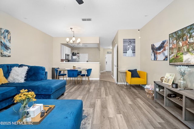 7540 Scarlet Ibis Ln, Jacksonville, FL 32256 - living area featuring visible vents, ceiling fan with notable chandelier, baseboards, and wood finished floors