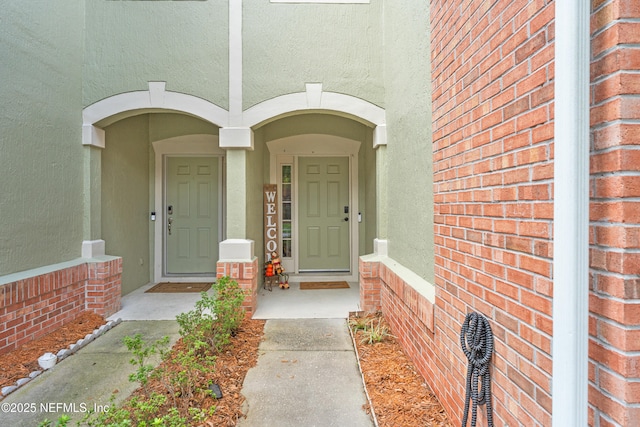 entrance to property with brick siding and stucco siding