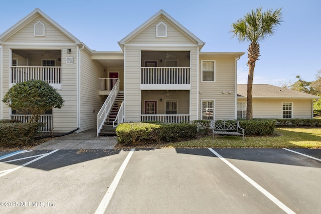 view of property featuring uncovered parking and stairs