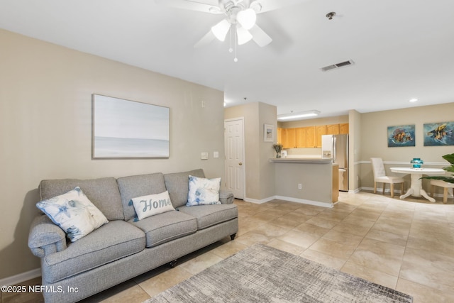 living area featuring light tile patterned floors, baseboards, visible vents, and ceiling fan