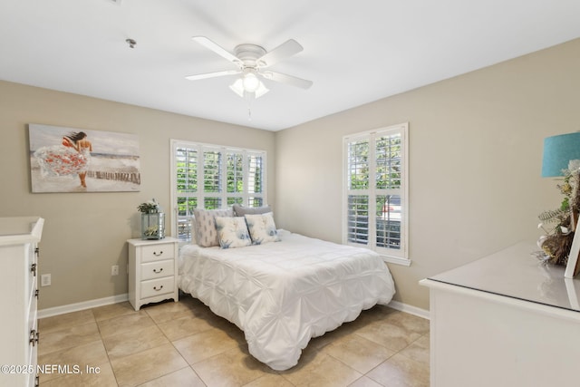 bedroom with baseboards, multiple windows, light tile patterned flooring, and a ceiling fan