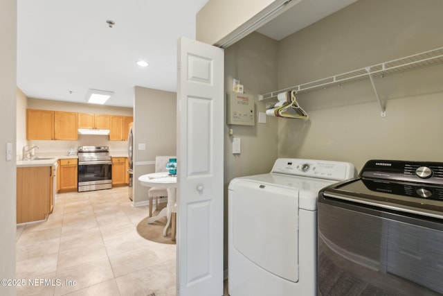 laundry area featuring laundry area, light tile patterned flooring, separate washer and dryer, recessed lighting, and a sink