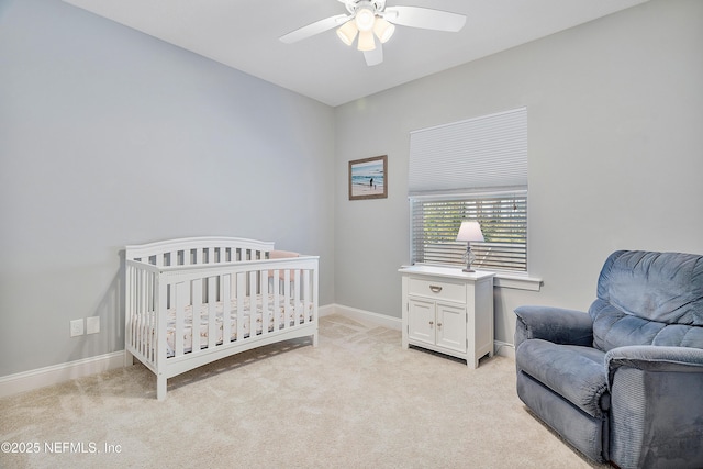 bedroom featuring light carpet, a ceiling fan, and baseboards