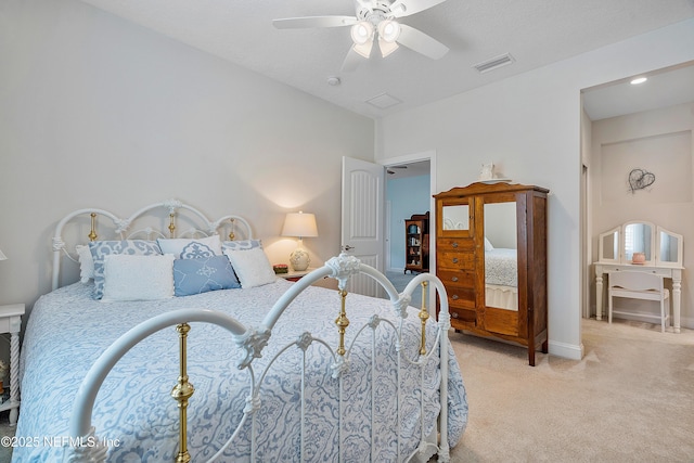 bedroom with baseboards, a ceiling fan, visible vents, and light carpet