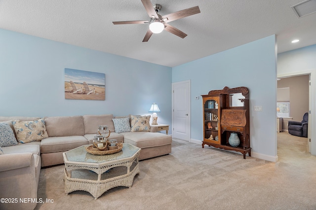 living area featuring visible vents, ceiling fan, baseboards, carpet, and a textured ceiling