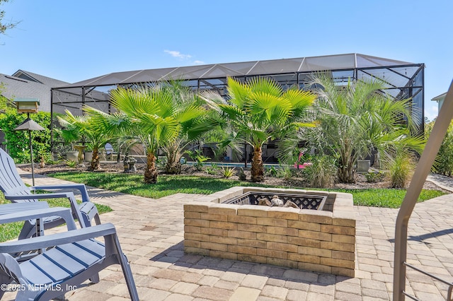 view of patio / terrace with glass enclosure and an outdoor fire pit