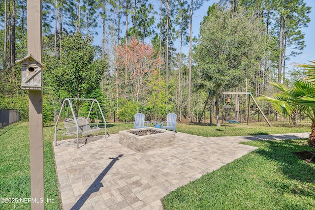 view of patio / terrace featuring a fire pit, a playground, and fence