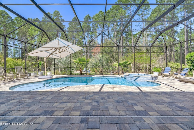 view of swimming pool featuring a patio area, a pool with connected hot tub, and a lanai