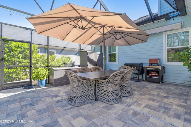 view of patio featuring a lanai, outdoor dining space, and grilling area