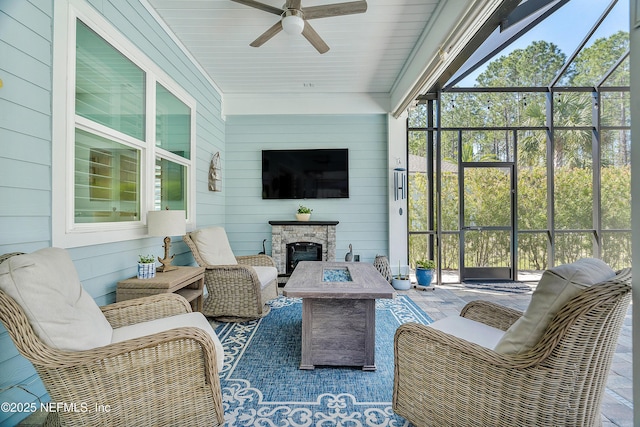 sunroom with a fireplace and ceiling fan