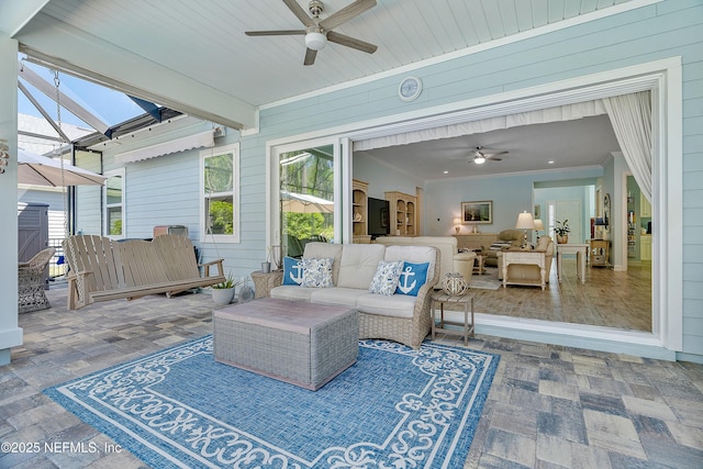 view of patio / terrace featuring an outdoor living space, glass enclosure, and a ceiling fan