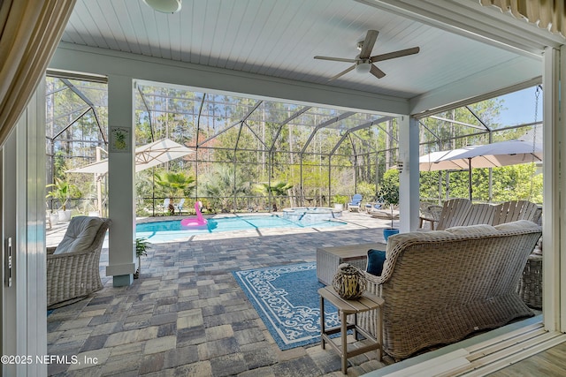 view of patio featuring a lanai, a pool with connected hot tub, and ceiling fan