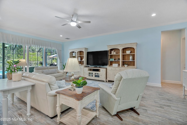 living area with light wood-style flooring, baseboards, crown molding, and a ceiling fan