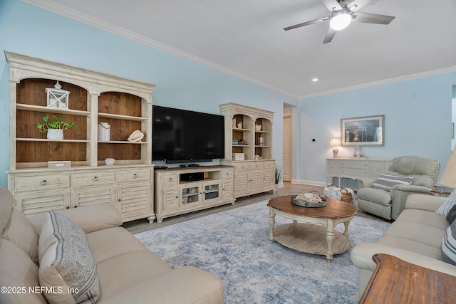 living area featuring baseboards, wood finished floors, a ceiling fan, and crown molding