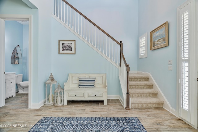 stairs with wood finished floors and baseboards