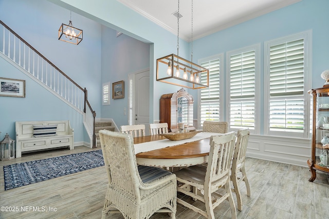 dining room featuring visible vents, stairs, ornamental molding, light wood-style flooring, and a notable chandelier