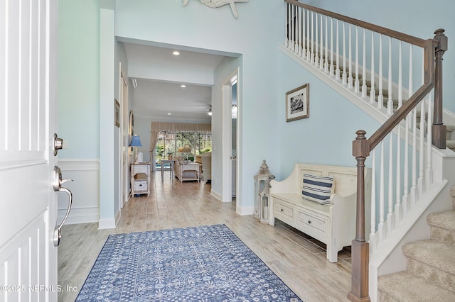 entrance foyer with crown molding, stairway, recessed lighting, and light wood-style floors