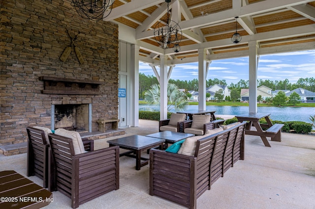 view of patio / terrace featuring a gazebo, a water view, and an outdoor living space with a fireplace