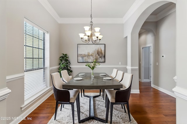 dining area with baseboards, an inviting chandelier, arched walkways, dark wood-style flooring, and ornamental molding