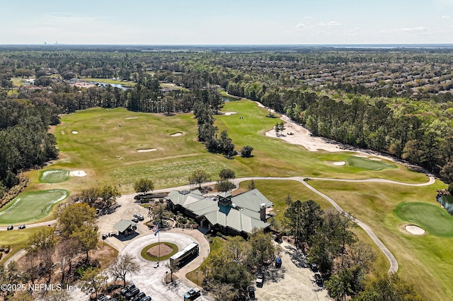 aerial view featuring golf course view and a wooded view