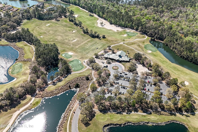 birds eye view of property with golf course view and a water view