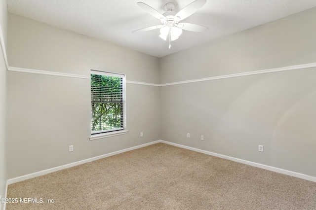 carpeted spare room featuring baseboards and ceiling fan