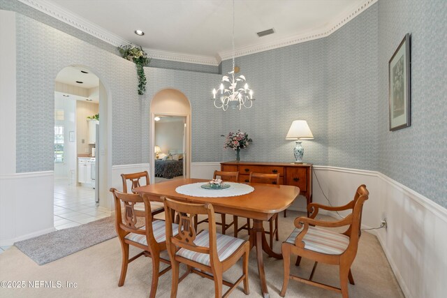 523 Lakeway Dr, Saint Augustine, FL 32080 - carpeted dining area featuring wallpapered walls, visible vents, arched walkways, and wainscoting