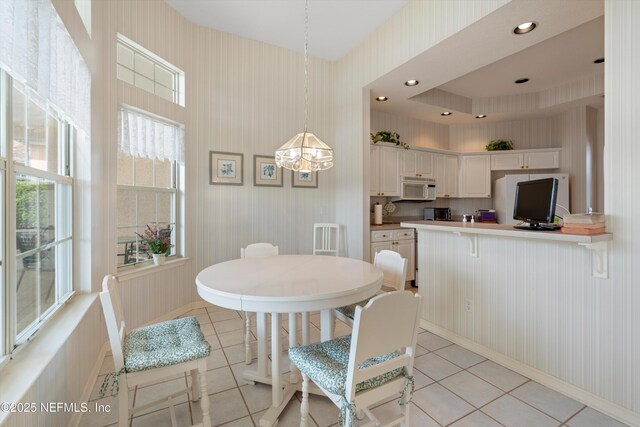 523 Lakeway Dr, Saint Augustine, FL 32080 - dining space with wallpapered walls, a chandelier, and light tile patterned floors
