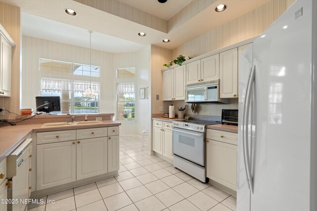523 Lakeway Dr, Saint Augustine, FL 32080 - kitchen with decorative light fixtures, white appliances, wallpapered walls, a sink, and light tile patterned flooring