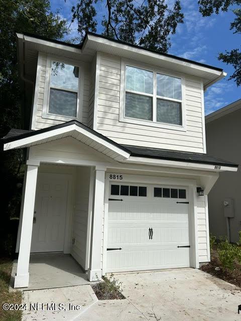 traditional home featuring an attached garage and driveway