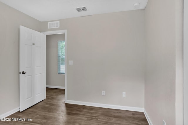 spare room featuring visible vents, baseboards, and wood finished floors