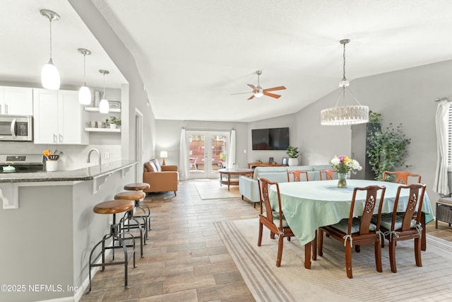 dining area featuring light wood-style flooring, ceiling fan, and vaulted ceiling