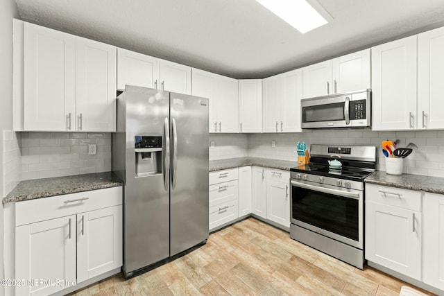 kitchen featuring white cabinets, light wood-type flooring, and stainless steel appliances