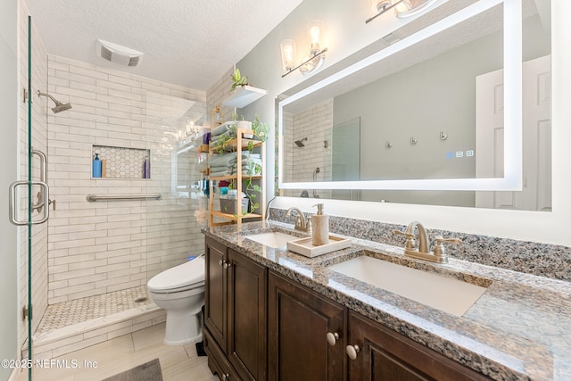 bathroom featuring a textured ceiling, a stall shower, and a sink