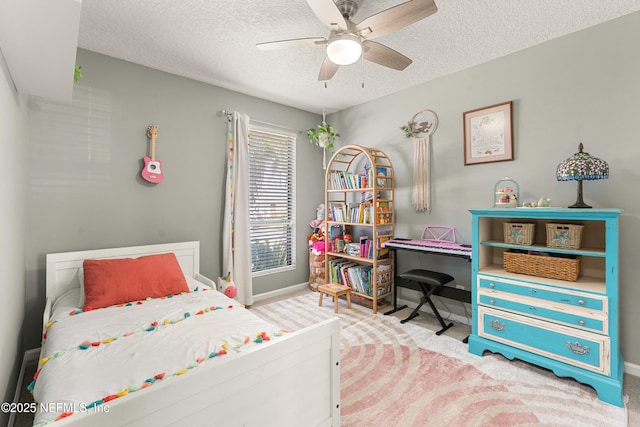 carpeted bedroom featuring baseboards, a textured ceiling, and ceiling fan