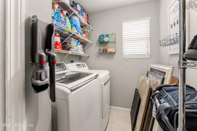 clothes washing area with laundry area, baseboards, and washer and clothes dryer