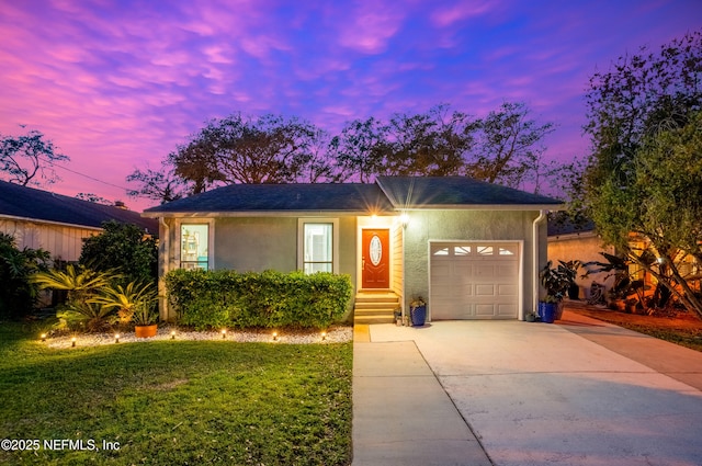 view of front facade featuring concrete driveway, an attached garage, a front lawn, and stucco siding