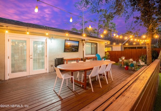 wooden deck featuring french doors, outdoor dining area, and fence