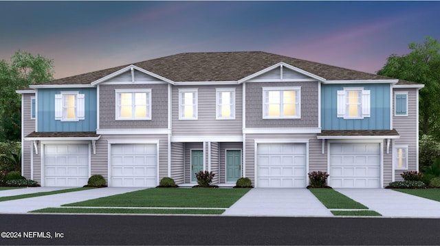 view of property with an attached garage, board and batten siding, a front lawn, and a shingled roof