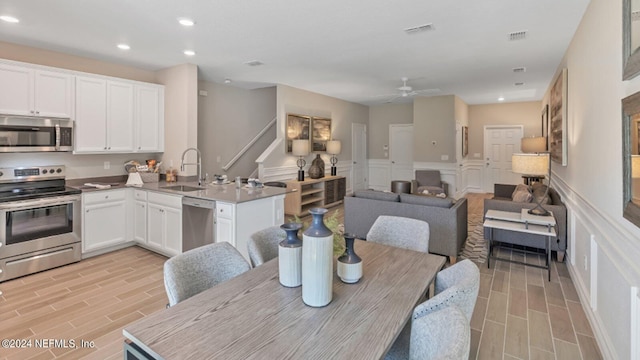 dining area with visible vents, wood finish floors, wainscoting, recessed lighting, and a decorative wall