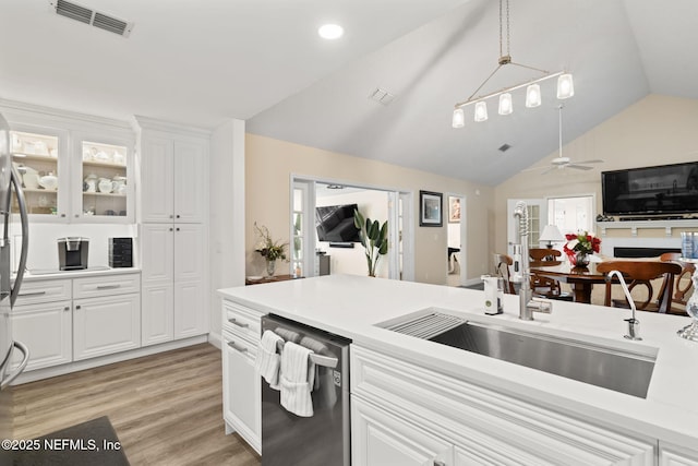 kitchen with visible vents, light wood-style flooring, a sink, light countertops, and dishwasher