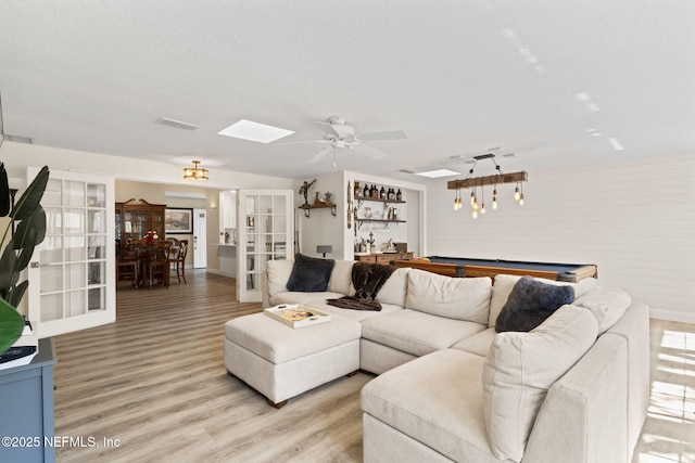 living area featuring light wood-type flooring, visible vents, a textured ceiling, french doors, and pool table