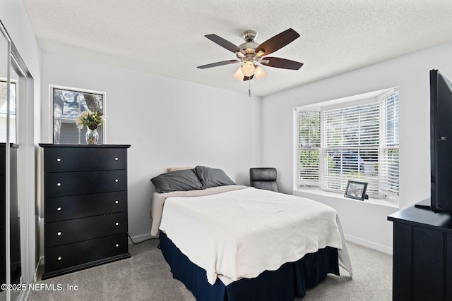 carpeted bedroom featuring ceiling fan, a textured ceiling, and baseboards