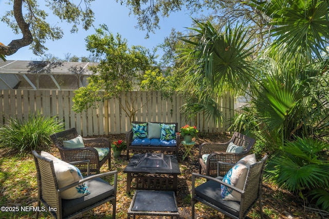 view of patio / terrace featuring an outdoor living space with a fire pit and fence