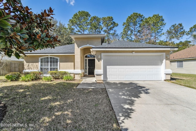 view of front of house with fence, stucco siding, concrete driveway, a front lawn, and a garage