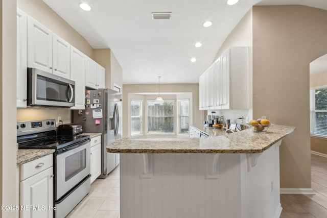 kitchen featuring visible vents, lofted ceiling, appliances with stainless steel finishes, and white cabinets