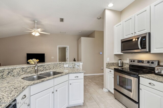 kitchen with a sink, stainless steel appliances, ceiling fan, and white cabinets