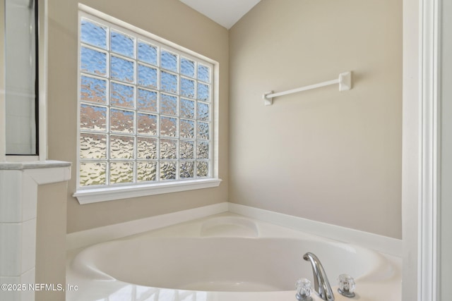 bathroom with a garden tub and a wealth of natural light